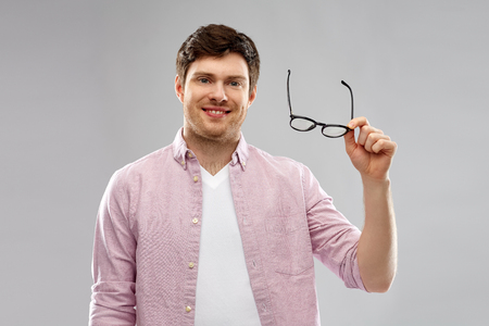 smiling man with glasses over grey backgroundの写真素材