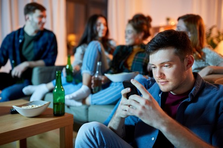 man with smartphone at home partyの写真素材