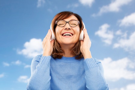 senior woman in headphones listening to music