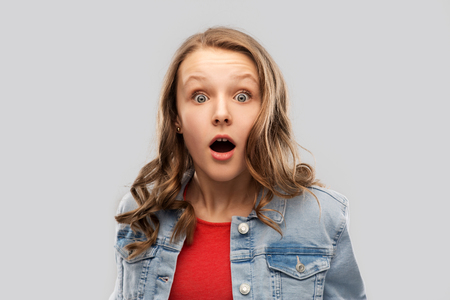 surprised or shocked teenage girl in red t-shirtの写真素材