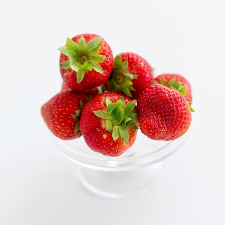 strawberries on glass stand over white backgroundの写真素材