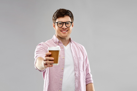 young man or student in glasses drinking coffeeの写真素材