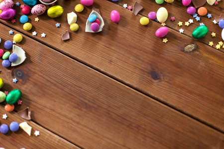 chocolate eggs and candy drops on wooden tableの写真素材