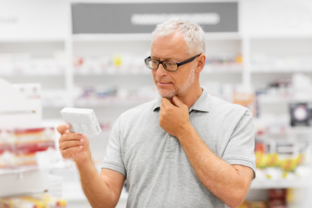 senior male customer with drug at pharmacyの写真素材