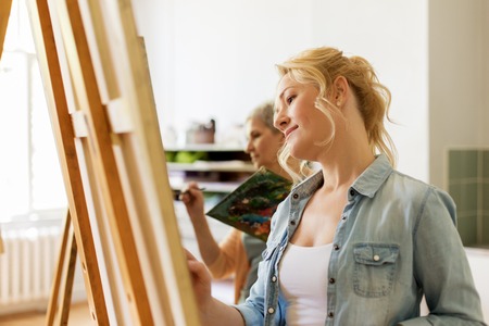 woman with easel drawing at art school studioの写真素材
