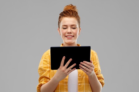 red haired teenage girl using tablet computerの写真素材