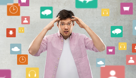 man touching his head over app icons on greyの写真素材