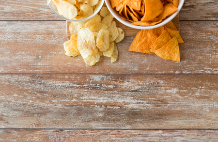 close up of potato crisps and nachos in bowlsの写真素材