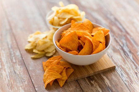 close up of potato crisps and nachos in bowlsの写真素材