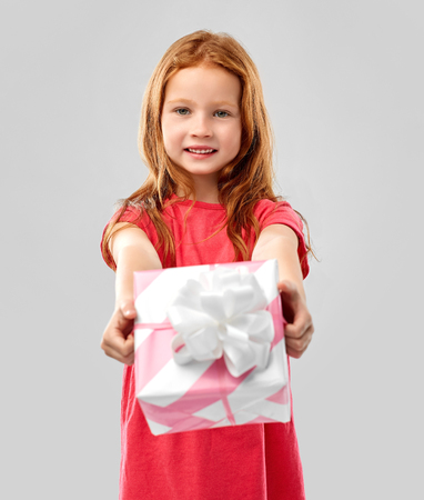 lovely red haired girl with birthday giftの写真素材