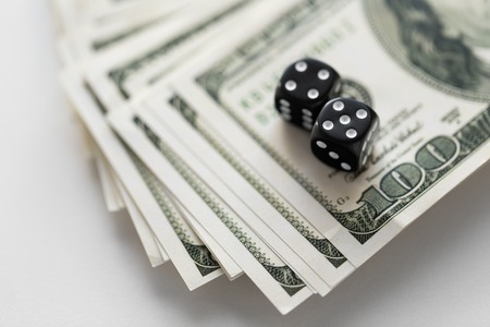 close up of black dice on dollar moneyの写真素材