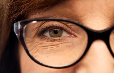 Beauty, vision and old people concept - close up of face of senior woman in glassesの写真素材
