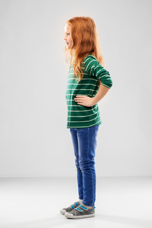 Smiling red haired girl posing in striped shirtの写真素材