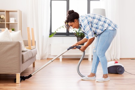 Woman or housewife with vacuum cleaner at homeの写真素材