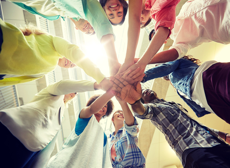 group of international students with hands on top