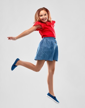 happy smiling girl in red shirt and skirt jumping
