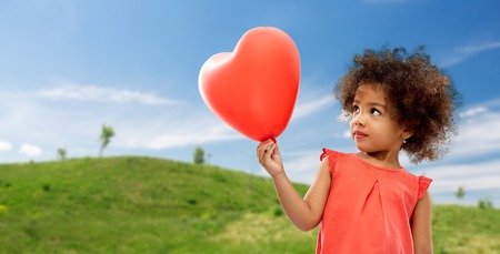 african american girl with heart shaped balloonの写真素材