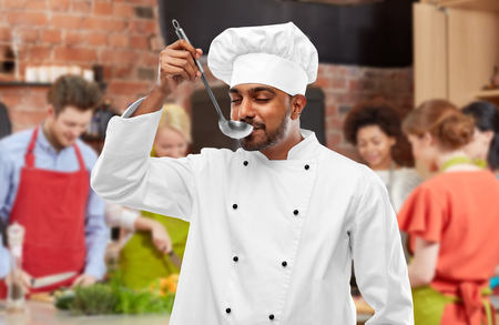 Chef tasting food from ladle at cooking classの写真素材