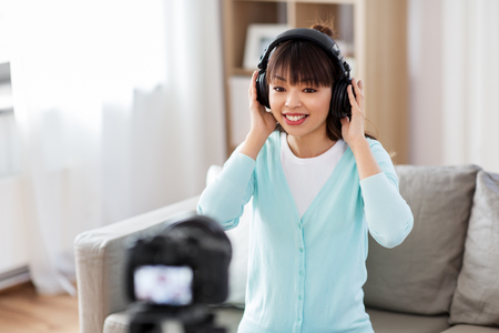 female blogger with headphones making video blogの写真素材
