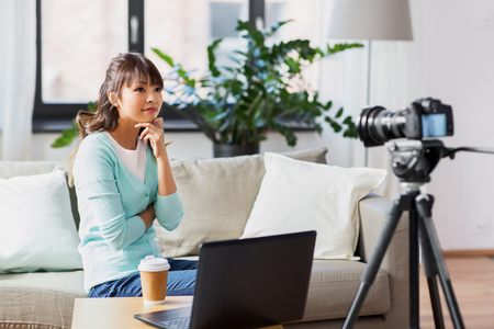 asian female blogger with camera recording videoの写真素材