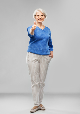 Smiling senior woman r showing thumbs upの写真素材