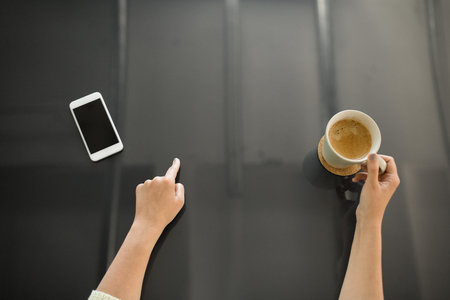 woman with coffee using black interactive panelの写真素材