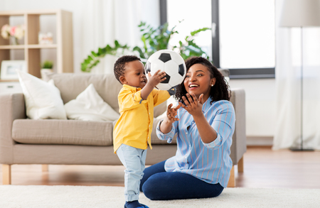 mother and baby playing with soccer ball at homeの写真素材