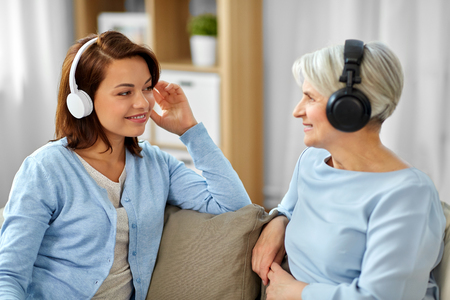 Senior mother and adult daughter with headphonesの写真素材