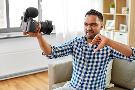 male video blogger with camera blogging at home