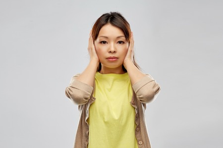 asian woman closing ears by handsの写真素材