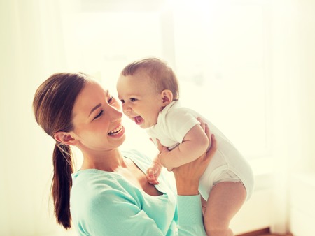 happy young mother with little baby at homeの写真素材