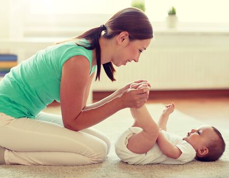 happy mother playing with baby at homeの写真素材