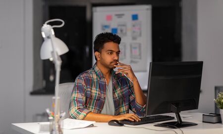 creative man with computer working at night office