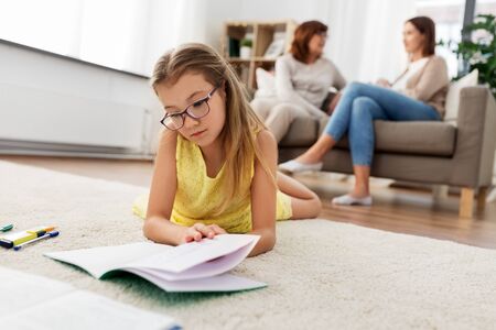 student girl with notebook lying on floor at homeの写真素材