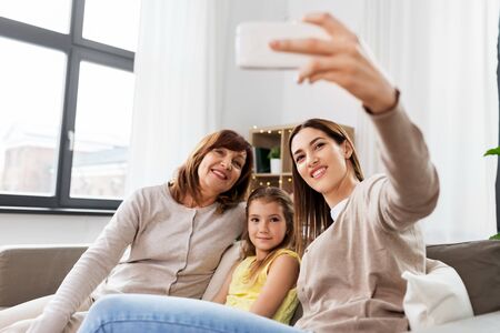 mother, daughter and grandmother taking selfieの写真素材