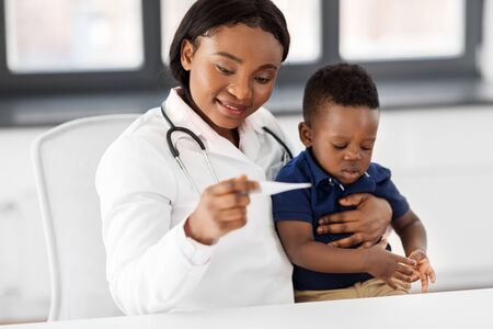 doctor with measuring babys temperature at clinic