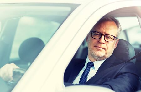 happy senior businessman driving car