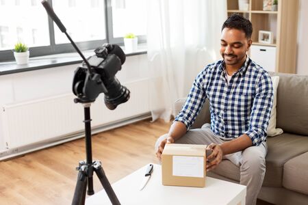 male video blogger opening parcel box at homeの写真素材