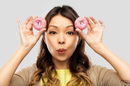 Happy Asian woman with donutsの写真素材