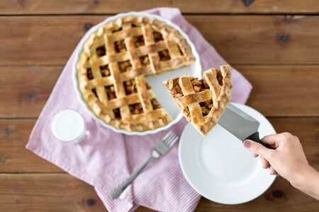close up of hand with piece of apple pie on knife