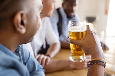 male friends drinking beer at bar or pub