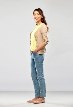 Happy Asian woman over grey backgroundの写真素材