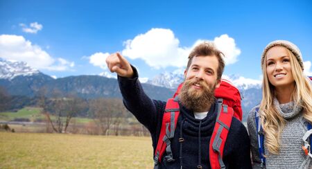 smiling couple with backpacks hiking in autumnの写真素材