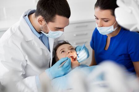 Dentist checking for kid teeth at dental clinicの写真素材
