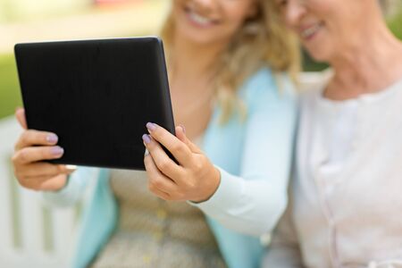 adult daughter and senior mother with tablet pcの写真素材