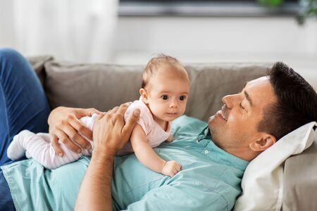 family, parenthood and fatherhood concept - happy smiling middle aged father with little baby...