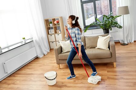 asian woman or housewife with mop singing at homeの写真素材