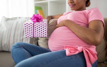 african american pregnant woman with giftの写真素材