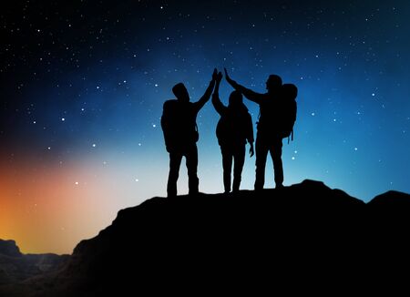 travelers making high five over starry night skyの写真素材