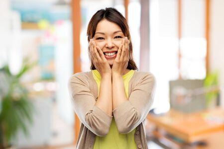 happy amazed asian woman over backgroundの写真素材